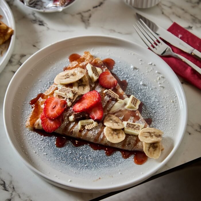 Madame Monsieur sweet crepe with strawberries, bananas, and white chocolate served with espresso in Budapest